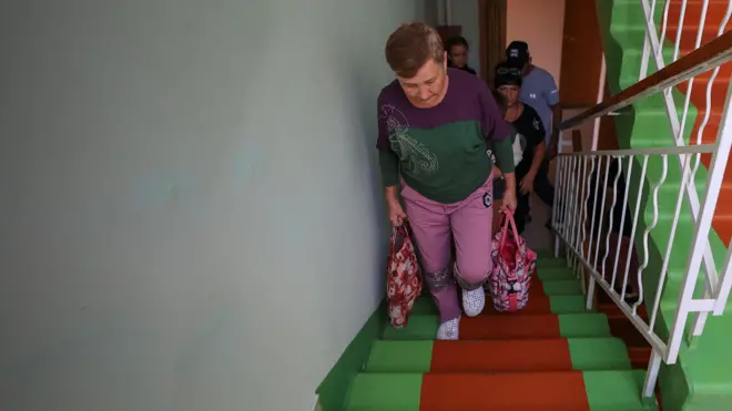 Женщина с сумками поднимается по лестнице