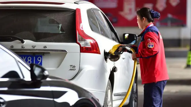 Frentista abastece um carro branco