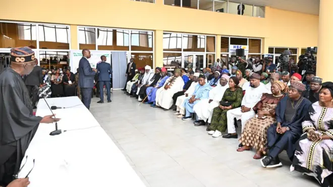 Aaẹ Bola Tinubu duro niwaju ọpọ ero ninu gbọngan nla kan nilu naa, o n bawọn eeyan to joko sọrọ