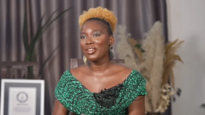 A lady on green wit yellow hair sitting down