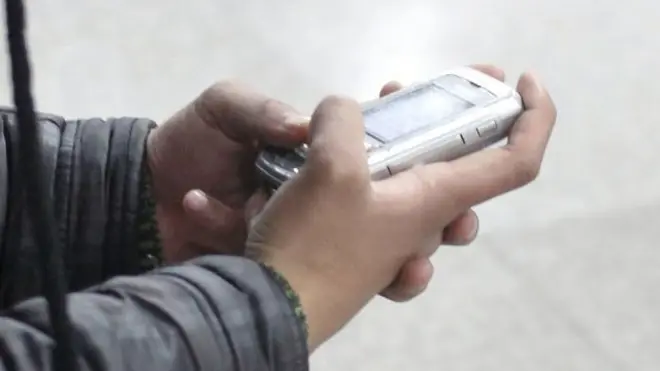 上海某地铁站内一位男子在閱读手机短信（19/1/2010）