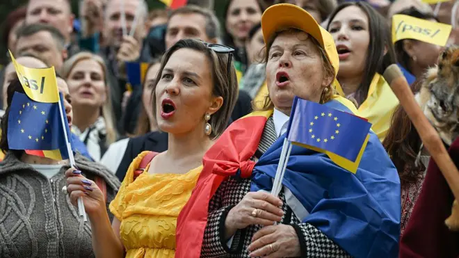 Проєвропейський мітинг у Молдові, на передньому плані - дві жінки з прапорцями Молдови та ЄС