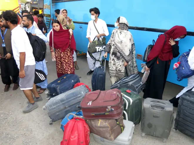 stanovnici Teherana sa koferima ispred autobusa