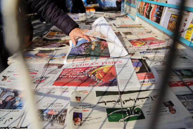 یک دکه روزنامه فروشی در تهران که روزنامهها روی آن چیده شده است