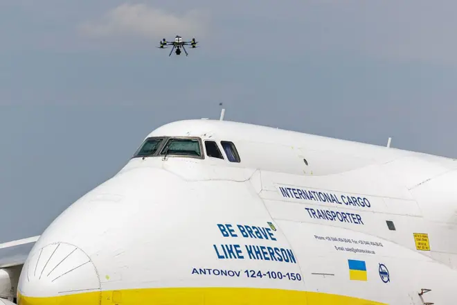 Поліцейський дрон злітає поруч з українським вантажним літаком в аеропорту Лейпциг/Галле 5 серпня 2026 року поблизу Лейпцига, Німеччина. Повідомляється, що працівники аеропорту вчора виявили дрон на злітній смузі біля літака "Антонов" в аеропорту, оснащеного детонатором вибухівки та невстановленою речовиною. Крім того, вантажний літак DHL, який вилетів з аеропорту пізно вчора ввечері, зіткнувся з невеликим об'єктом, що завдало йому незначних пошкоджень. (Фото Єнса Шлютера/Getty Images)