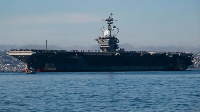 USS Abraham Lincoln Aralık 2024'te San Diego'ya yaklaşırken yüzlerce denizci güvertede yan yana durmuş 