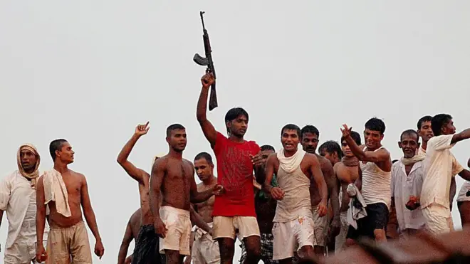 Sri Lankan prisoners climb onto a roof to get a view of a building set on fire by rioting inmates at Welikada prison in Colombo on November 9, 2012