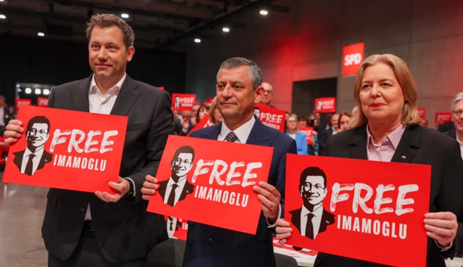 SPD'nin yeni eş genel başkanları Lars Klingbeil ve Bärbel Bas'ın arasında Özgür Özel duruyor. Fotoğraftaki çok sayıda kişi İmamoğlu'na Özgürlük pankartları taşıyor.