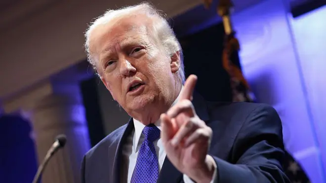 Donald Trump durante una alocución con traje y corbata azul