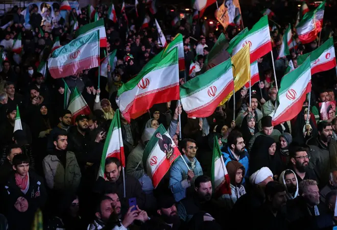 Iranians react after a ceasefire announcement at the Enqelab square, in Tehran, on April 8 2026. 