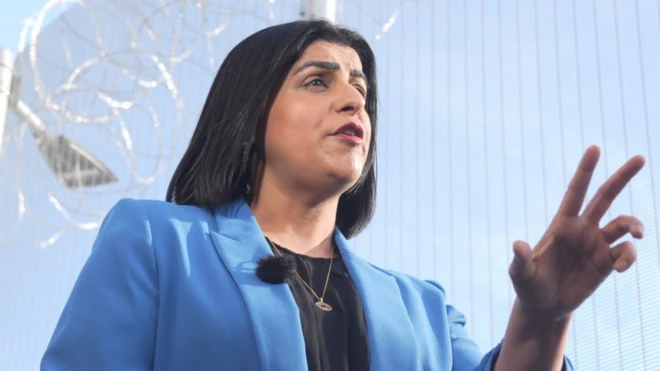 Министр юстиции Шабана Махмуд выступает на фоне забора из колючей проволоки