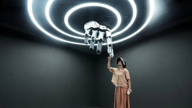 2025年8月4日，在位于中国北京亦庄的“机器人商城”——全球首家具身智能机器人4S店，一名参观者正在与机械手互动。该设施计划于2025年世界机器人大会期间（8月8日至12日）在北京南部亦庄的机器人产业园内开业。