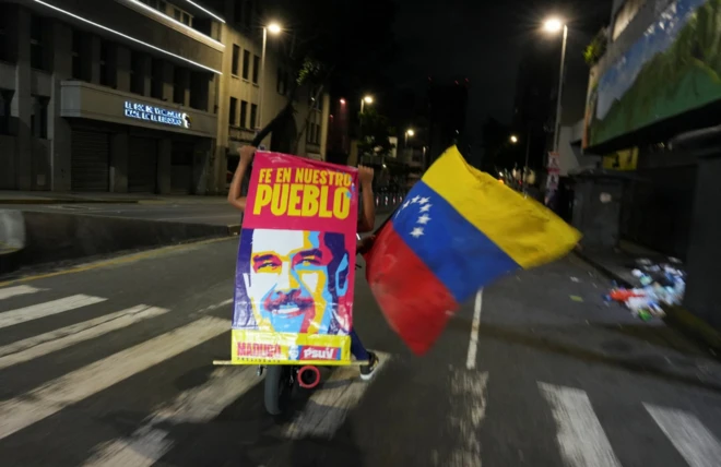 Motocicleta com apoiadorcasino online bonus ohne einzahlungMaduro segura cartaz com imagem do líder venezuelano e bandeira da Venezuela