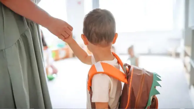 مادری که دست بچه اش را گرفته است