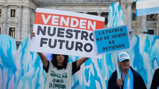 Una mujer joven y un hombre mayor participan en una manifestación ecologista contra la aprobación de la ley de glaciares en Buenos Aires, Argentina.