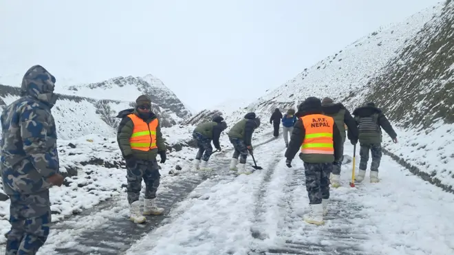 मुस्ताङमा राजमार्गमा जमेको हिउँ पन्छाउँदै सुरक्षाकर्मीहरू