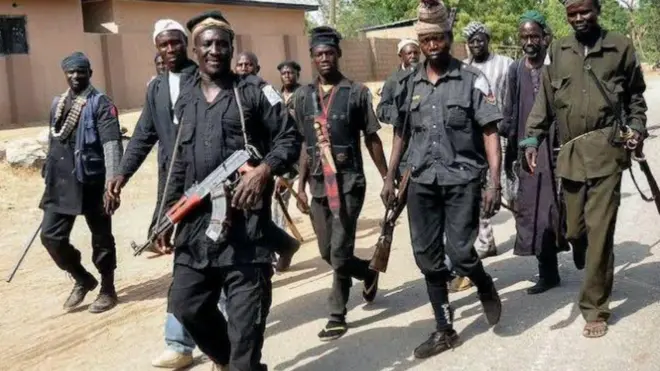 Awọn Ọdẹ aṣọgbo wọ asọ dudu, wọn to mejila, ti wọn si n rin lọ loju popo pẹlu ibọn lọwọ ẹni kọọkan wn.