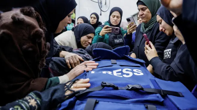 صورة لعدد من النساء يحتشدن حول جثمان شذى الصباغ التي قُتلت أثر اشتباكات في مخيم جنين، ويظهر الجثمان مغطى بسترة زرقاء يرتديها الصحفيون في مناطق النزاعات.