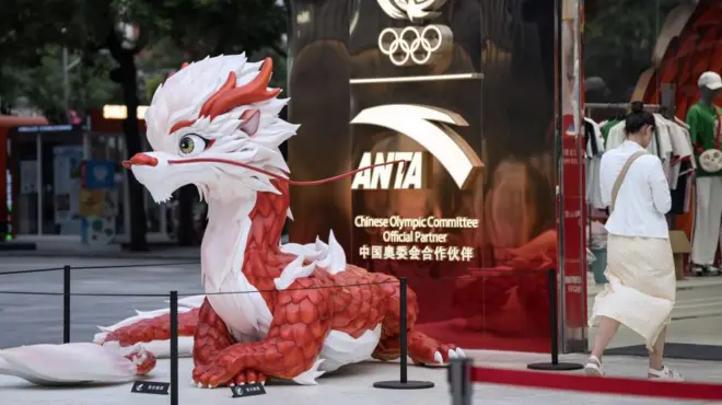 logo de anta con una estatua de un dragón chino en frente 
