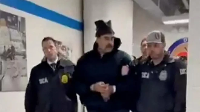 Presiden Venezuela tiba di AS dan diapit dua petugas.