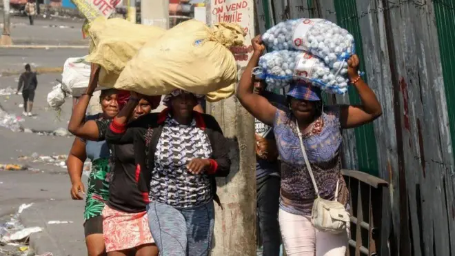 Pipo run comot dia homes hold dia belongings to escape gang violence, as Haiti kontinu for state of emergency, for Port-au-Prince, Haiti March 6, 2024.