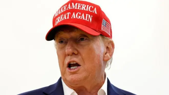 Donald Trump yambaye ingofero itukura yanditseho "make America great again" (cyangwa ongera ugire Amerika igihangange, ugenekereje mu Kinyarwanda)