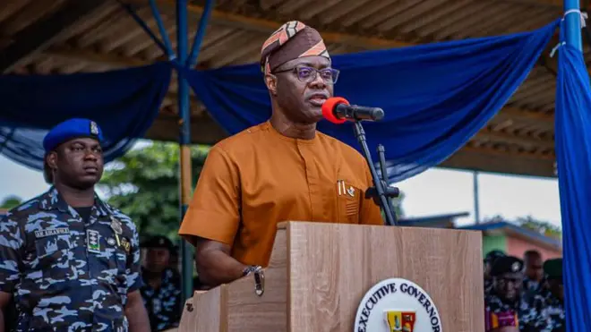 Seyi Makinde wọ aṣọ alawọ paali, gbohungbohun wa niwaju rẹ