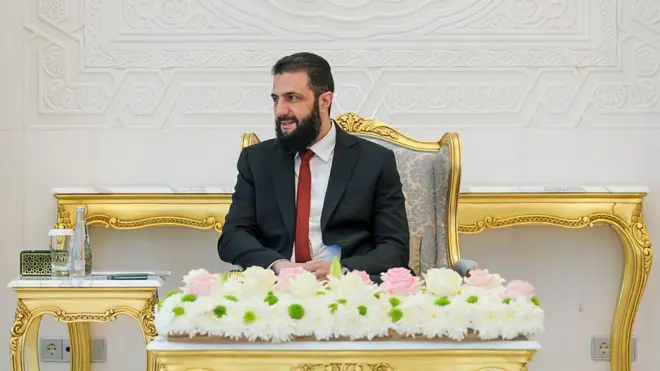 Şara altın varaklı bir koltukta oturuyor 