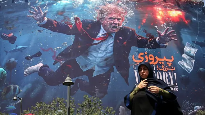 İran'ın Tahran kentinde, 25 Ağustos 2026 tarihinde çekilmiş büyük bir reklam panosunda, ABD Başkanı Donald Trump ve panonun önünden geçen bir kadın görülüyor. 