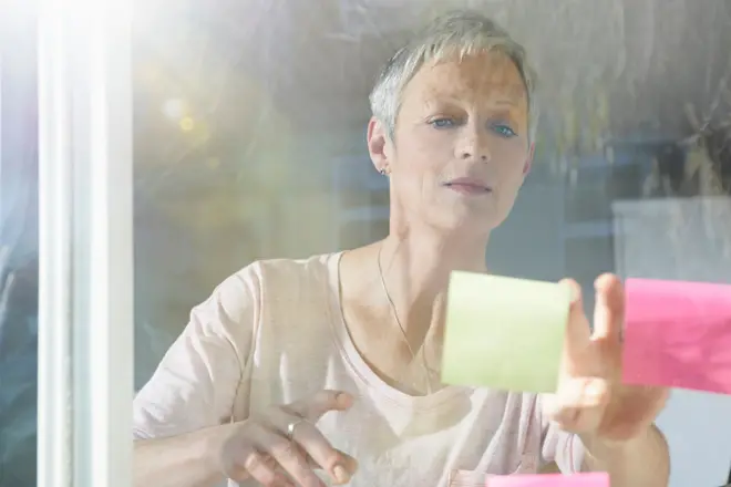 Mulher madura colando post-its