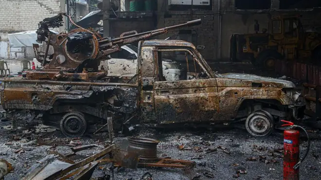 Halep'te Kürt silahlı güçlere ait yanmış bir pikap araç. Aracın üzerinde ağır silah teçhizatı görülüyor. 