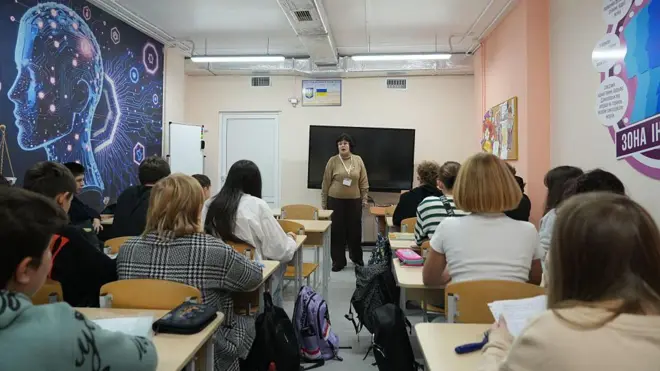 Клас, де сидять учні, їх видно зі спини.