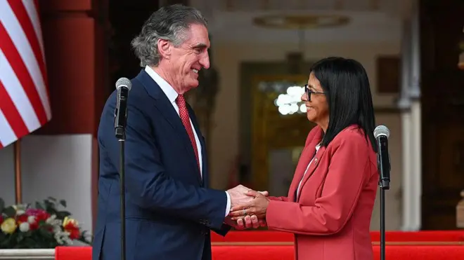 El secretario del Interior de Estados Unidos, Doug Burgum, y la presidenta encargada de la República Bolivariana de Venezuela, Delcy Rodríguez, mirándose de frente y dándose la mano el 5 de marzo de 2025 en el palacio de Miraflores, Caracas, Venezuela. (Foto: Federico PARRA / AFP vía Getty Images)