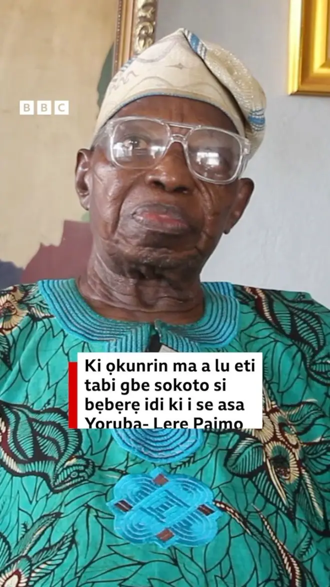Àgbà òṣèré Lere Paimo wọ ìgò ojú, ó jókòó, ó ń wo ọ̀ọ́kán