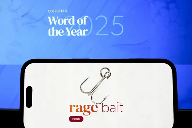مصطلح استدراج الغضب بالانجليزية على شاشة هاتف ذكي أمام خلفية زرقاء عليها شعار كلمة العام 2025 من قاموس أكسفورد.