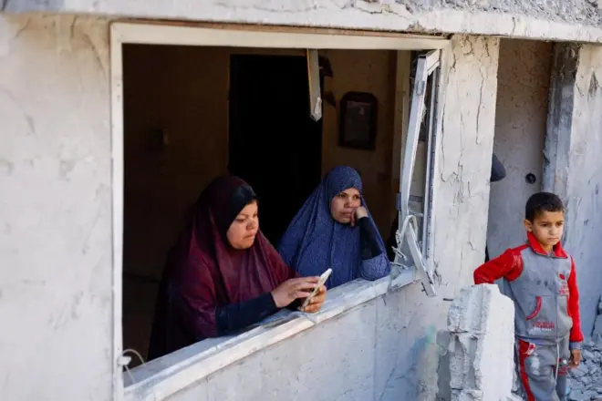 Palestinians look on at the site of an Israeli strike on a house in the southern Gaza Strip on 4 April 2024