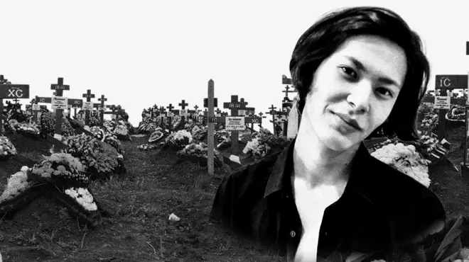 Image of Murat Mukashev with a cemetery behind him