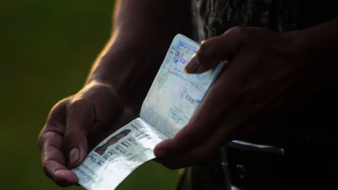 A man opens his passport to show his visa