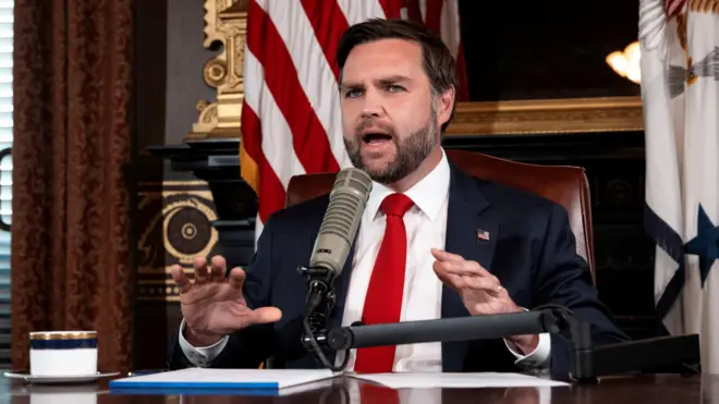 Вице-президент Джей Ди Вэнс, в костюме с красным галстуком ведет выпуск The Charlie Kirk Show, сидя за столом в Белом доме 