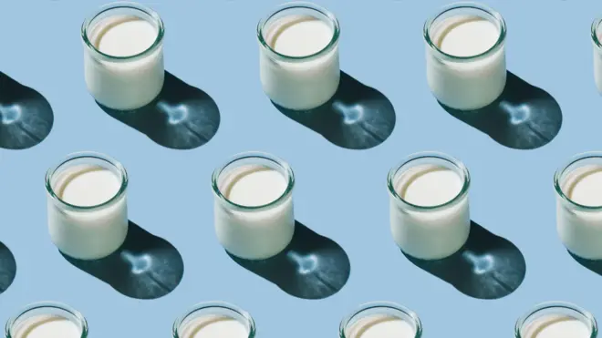 Soluk mavi bir arka plan üzerinde çapraz çizgiler halinde dizilmiş küçük kefir bardakları.
