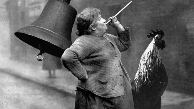 Une femme tient un batonnet à la bouche soutenu par sa main gauche, la tête levée vers le ciel. A sa gauche se trouve un coq et derrière elle une cloche.