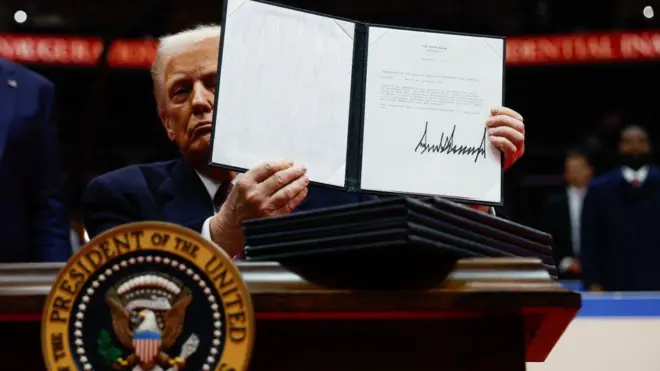 الرئيس الأمريكي دونالد ترامب يستعرض أمراً تنفيذياً بعد توقيعه في 20 يناير/كانون الثاني 2025 في واشنطن