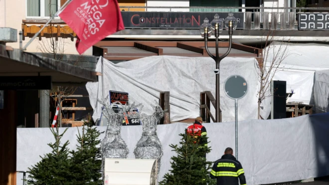 Beyaz brandalarla kapatılmış mekanın ön kapısında iki tane üniformalı görevli var.