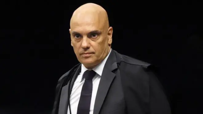Alexandre de Moraes de toga, observando algo 