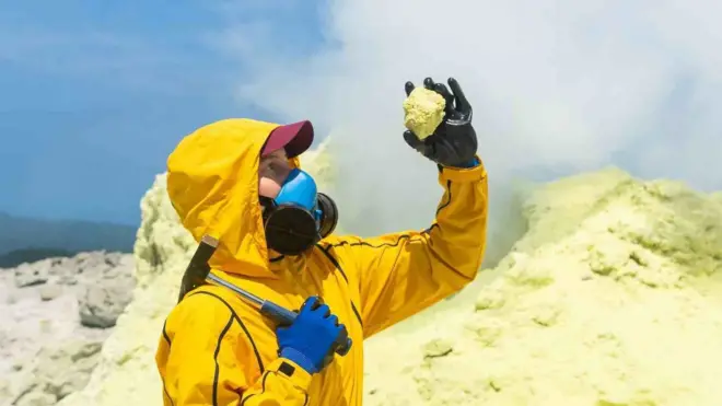 Una vulcanóloga mirando una piedra volcánica