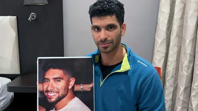 Ilay David sostiene un póster de su hermano Evyatar David.