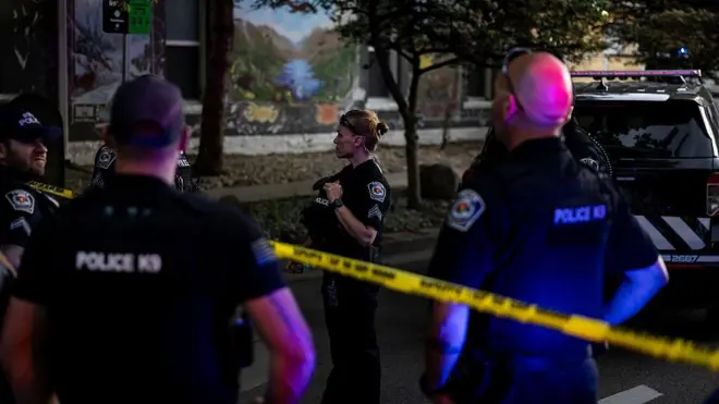 Polis kordonunun önünde ve arkasında polis memurları