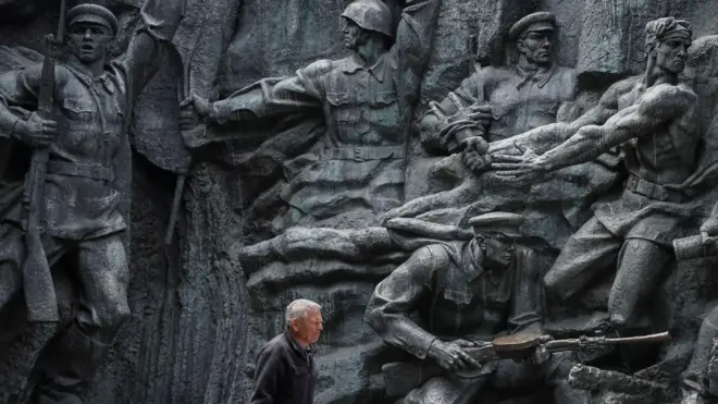 رجل يمر أمام نحت بارز من زمن الاتحاد السوفياتي في المتحف الوطني لتاريخ أوكرانيا في الحرب العالمية الثانية في كييف