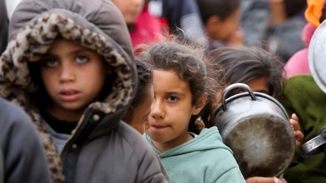 أطفال ينتظرون استلام الطعام خلال شهر رمضان في خان يونس 