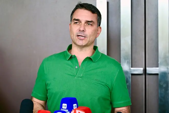 Flávio Bolsonaro usando uma camisa verde dando entrevista